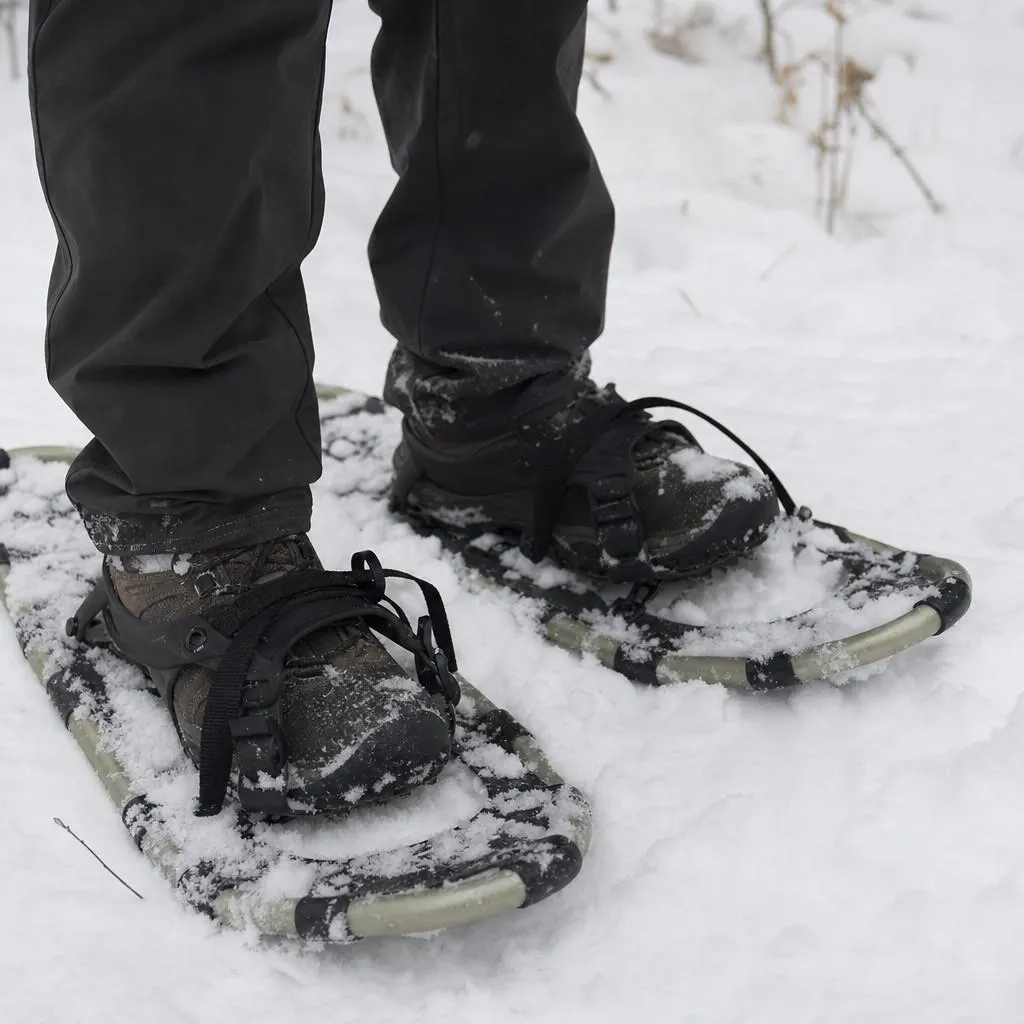 Close view of simple snowshoes strapped to winter boots in fresh snow
